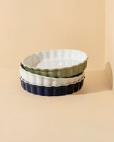 A ceramic pie dish with wavy sidewalls in shades of blue and white, displayed against a neutral background.
